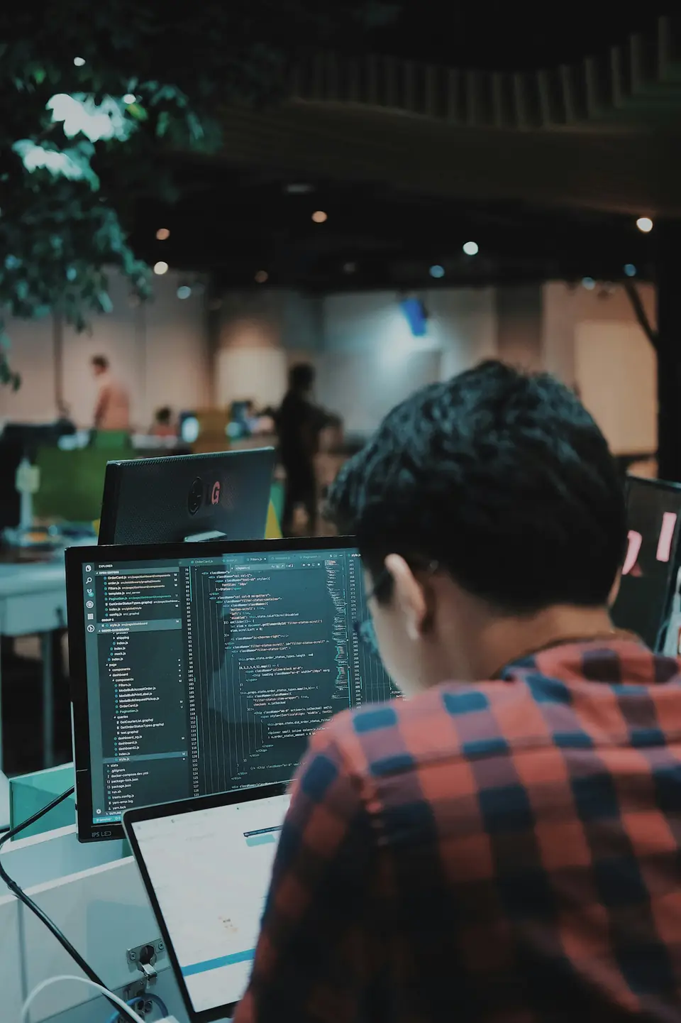 Developer working in front of two monitors displaying code