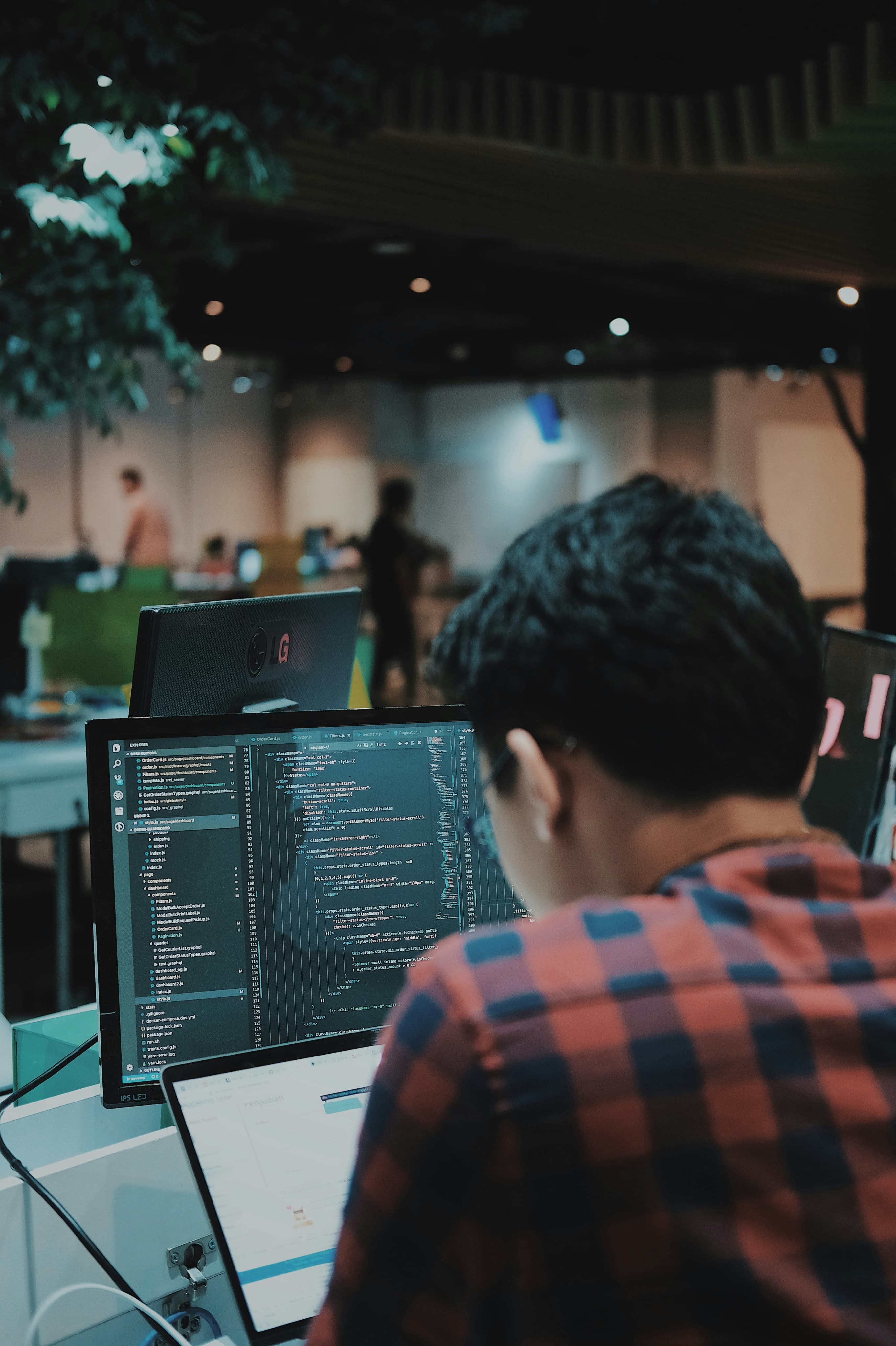 Developer working in front of two monitors displaying code